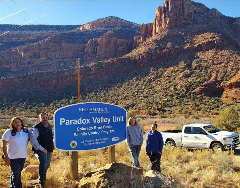 The Veolia PVU team stands by the project sign